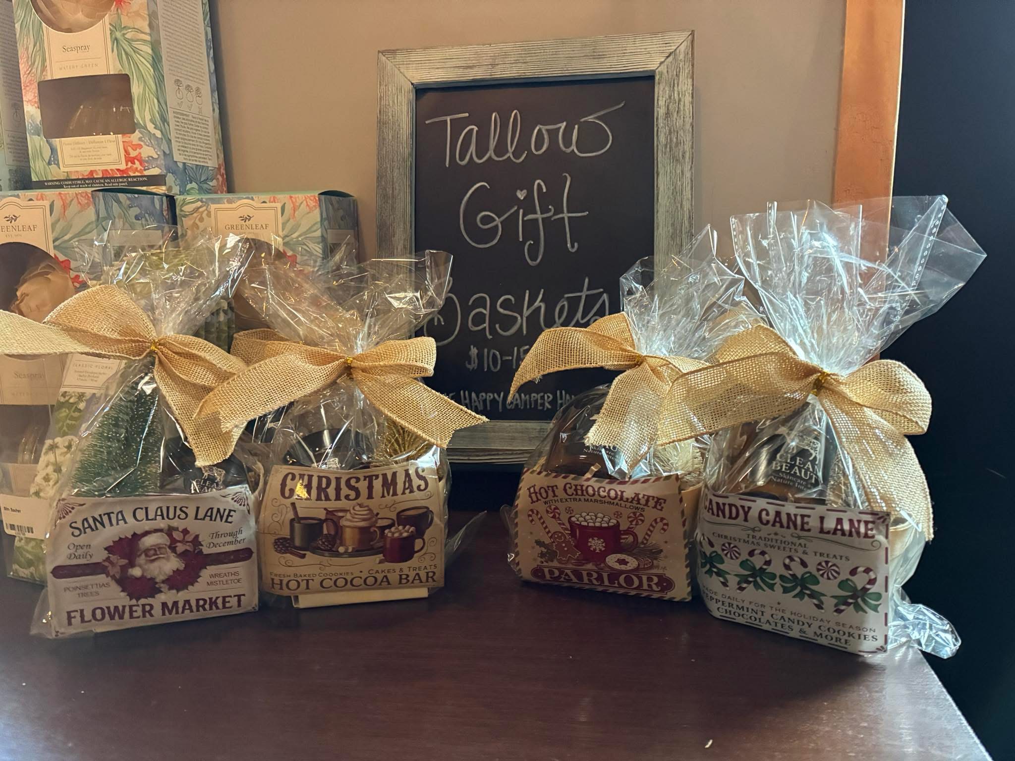 Wrapped holiday gift baskets with Christmas-themed labels.