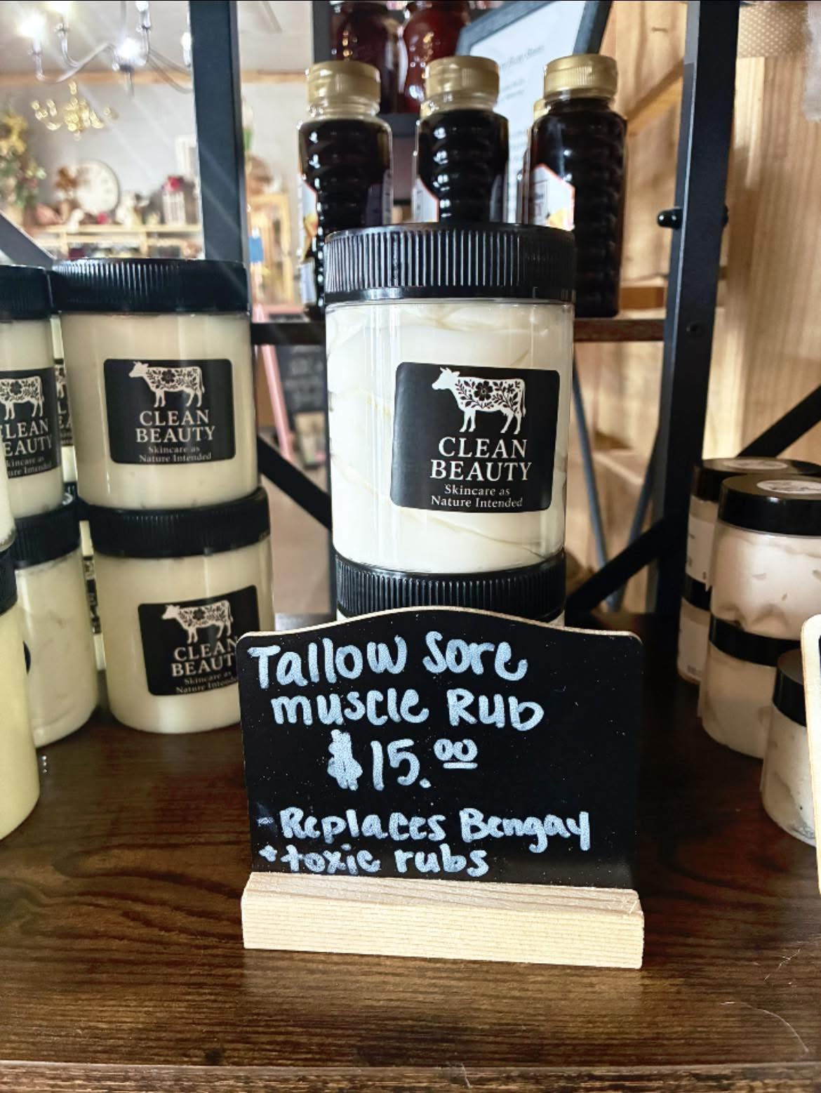 Jars of tallow muscle rub from Clean Beauty with a handwritten sign.